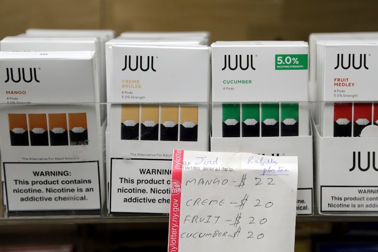FILE - In this Thursday, Dec. 20, 2018 file photo, Juul products are displayed at a smoke shop in New York. On Thursday, Oct. 17, 2019, the company announced it will voluntarily stop selling its fruit and dessert-flavored vaping pods.