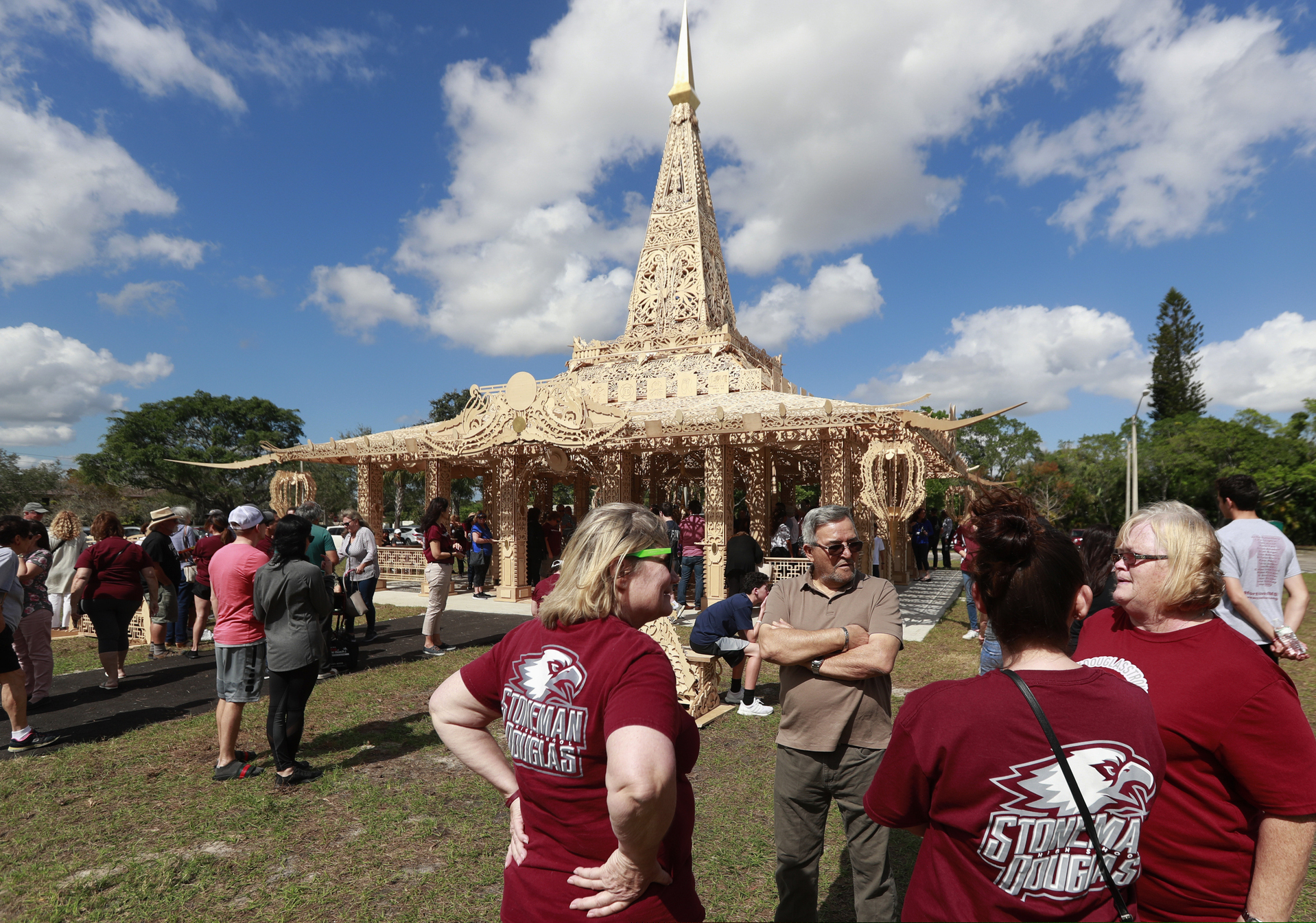 FILE - In this Feb. 14, 2019, file photo, people gather around the "Temple of Time" in honor of the 17 that were killed during the Marjory Stoneman Douglas High School shooting in 2018 in Coral Springs, Fla. The temple built as a memorial to the 17 victims of a Florida high school mass shooting was set afire in a symbolic gesture of healing.
