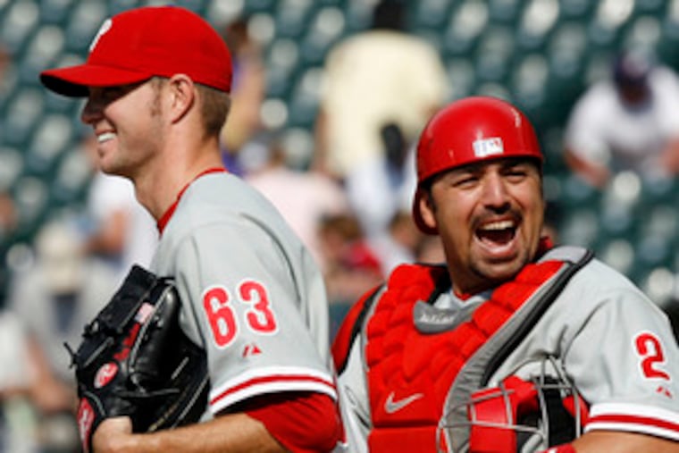 Reliever Ryan Madson and catcher Rod Barajas celebrate after getting the last out against the Rockies. Madson pitched the final three innings to pick up his first save of the season.