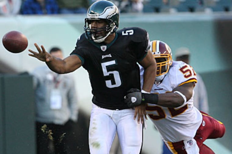 Donovan McNabb shovels a pass against Washington Redskins'
Rocky McIntosh during the third quarter last Sunday. (Yong Kim / Staff Photographer)