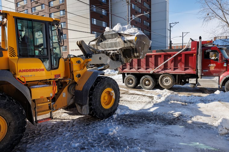 Heavy machinery and dump trucks collecting piles of snow from Germantown and Thompson Street on Wednesday.