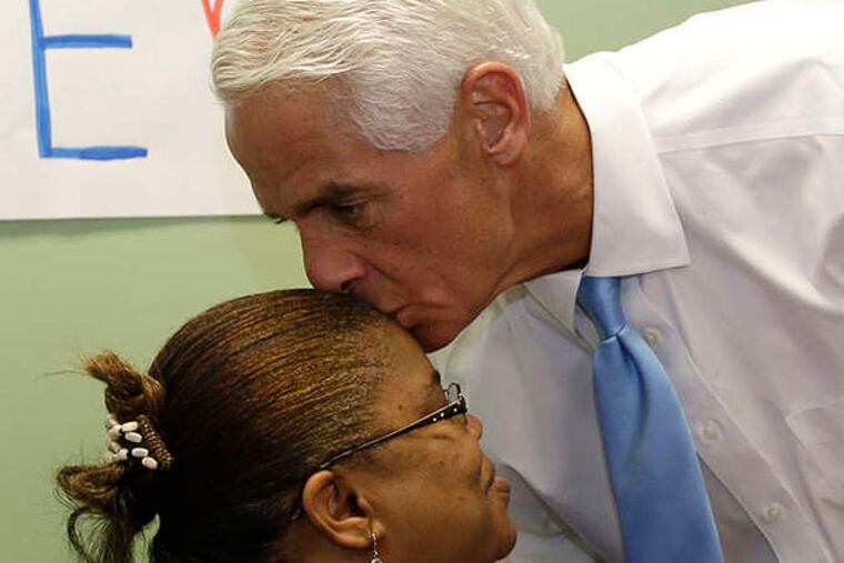 Former Florida Gov. Charlie Crist, right, kisses volunteer Edouine Belot, of Fort Lauderdale, left, on the head during a visit to a phone bank, Monday, Aug. 25, 2014, in Fort Lauderdale, Fla. Crist is running against Nan Rich for the democratic nomination for Florida Governor. Florida's primary election is Tuesday. (AP Photo/Lynne Sladky)
