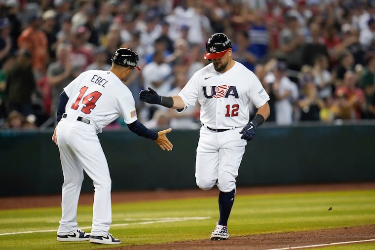 Kyle Schwarber celebrates with third base coach Dino Ebel after hitting a three-run home run against Great Britain on Saturday in the World Baseball Classic.