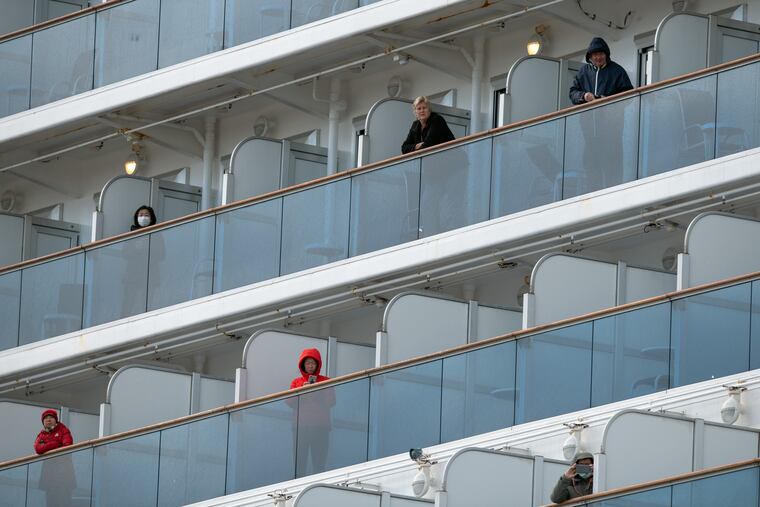Passengers look out from balconies on the Diamond Princess cruise ship.