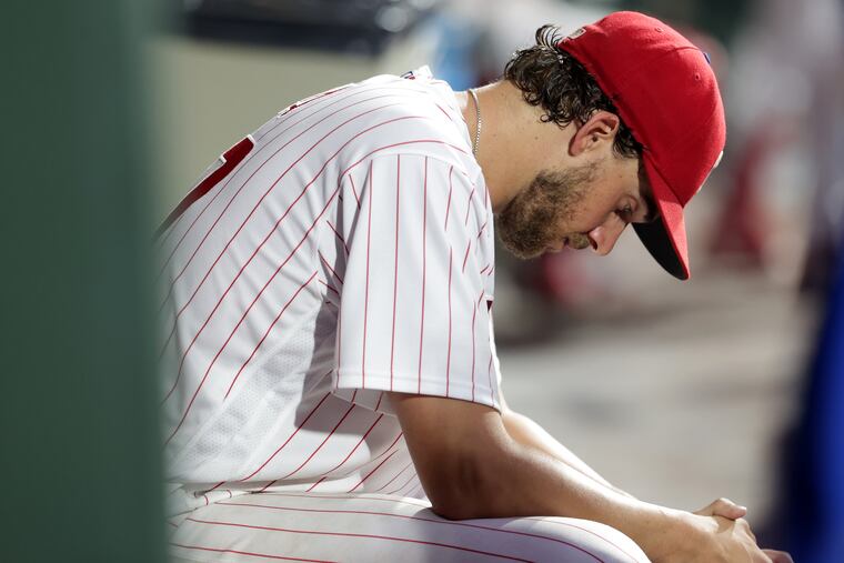 Aaron Nola of the Phillies sits in the dugout in the 4th inning with his team trailing 3-0 against the Braves on July 26, 2022.