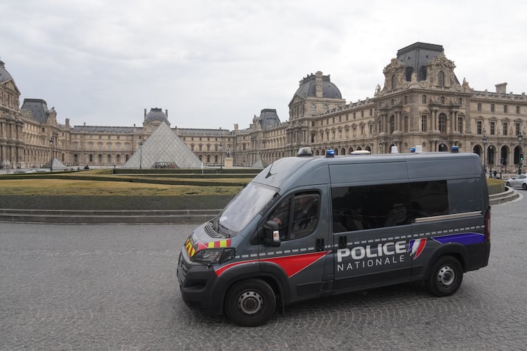 A police van patrols the courtyard of the closed Louvre after a robbery on Sunday in Paris.