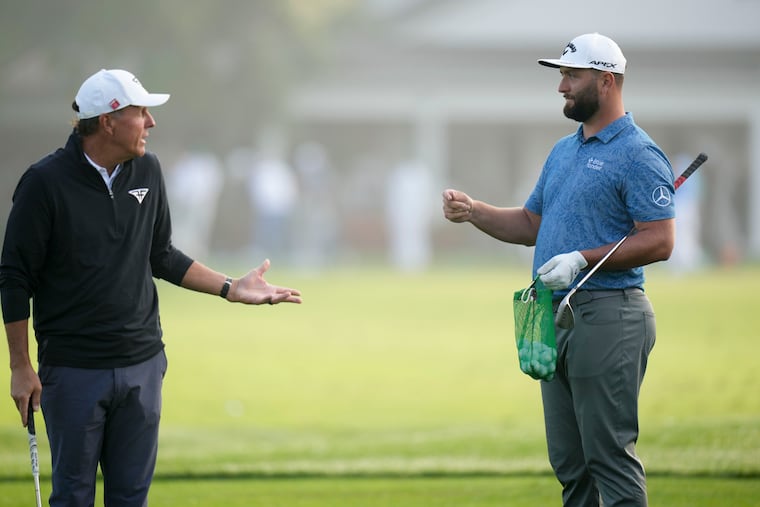 Phil Mickelson, left, and Jon Rahm talk on the range before a practice round at the Masters on Wednesday. Phil winning his fourth green jacket would be good for golf, writes Marcus Hayes.