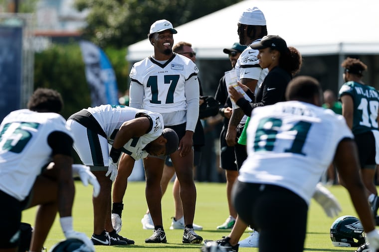 Eagles linebacker Nakobe Dean laughs with teammates during the first day of training camp. Dean tore his left patellar tendon in a playoff win over Green Bay and has been sidelined since.