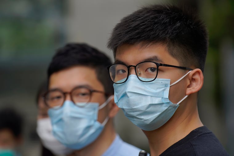 Hong Kong politic activist Joshua Wong, right, and Nathan Law, left, speaks to media outside Legislative Council Complex after a second-day legislative debate on a contentious bill in Hong Kong that aims to criminalize insult and abuse of the Chinese national anthem.