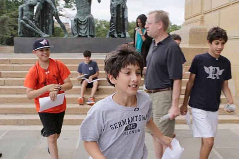 Away they go: Danny Loder (front) of Philadelphia and teammate Justin Needles (ballcap) of Cheltenham run into the Art Museum on a "Museum Madness" scavenger hunt, organized by Watson Adventures. (Staff Photographer/Elizabeth Robertson)