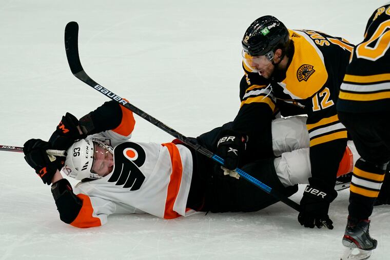 Boston Bruins right winger Craig Smith (12) takes down Flyers right winger Jake Voracek (93) during the first period Thursday. Voracek set up the Flyers' second goal, collecting his 699th career point.