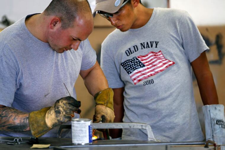 Joe Blubello (left) gives Gilberto "Chango" Guerra, 22, some welding tips during a tutorial at Car Cure in West Chester. Guerra, who has basic welding skills in Honduras, is learning more advanced techniques while visiting in the area. September 18, 2014. ( MICHAEL S. WIRTZ / Staff Photographer )