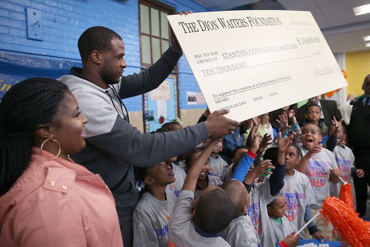 The Oklahoma City Thunder's Dion Waiters, left, gave $10,000 to help build a green playground as he visits his former school, Edward Stanton Middle School.