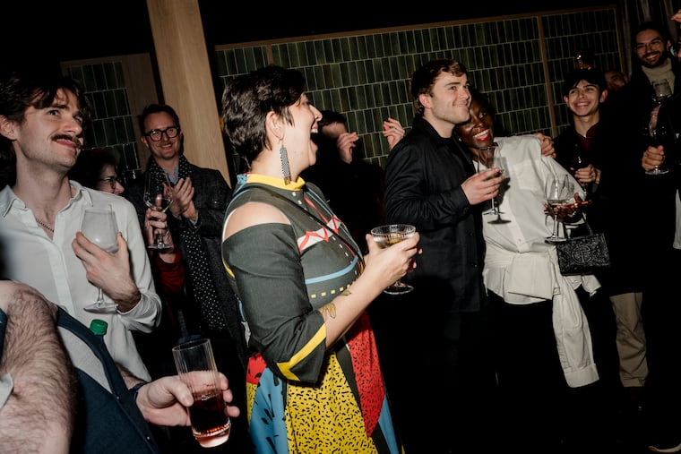 The composer Alistair Coleman, center right in black, hugs his fellow composer Nathalie Joachim during the after-party for the opening night of “Complications in Sue,” at the Kimmel Center in Philadelphia, Feb. 4, 2026. Anthony Roth Costanzo took over Opera Philadelphia when it was “three weeks away from stopping payroll” — now, it is rebounding with a surplus.