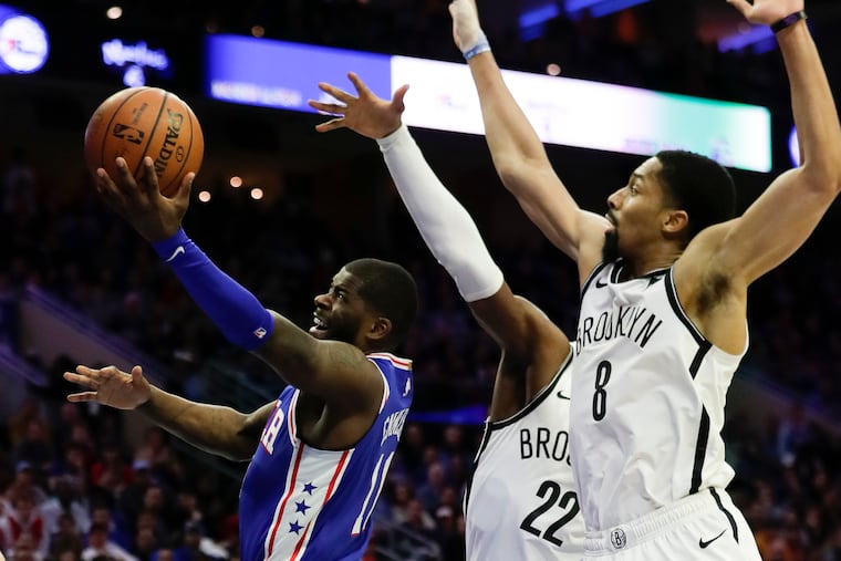 Sixers forward James Ennis III lays-up the basketball against Brooklyn Nets guard Caris LeVert (center) and guard Spencer Dinwiddie in game two of the Eastern Conference playoffs on Monday, April 15, 2019 in Philadelphia.