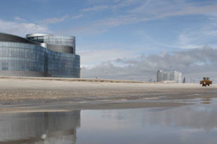 A bulldozer working on the beach and dune fortification project passes the Revel Casino construction site in Atlantic City in Sept. 2011. ( Elizabeth Robertson / Staff Photographer )