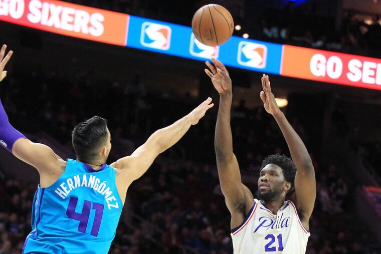 Joel Embiid, right, of the Sixers shoots a 3-pointer over Willy Hernangomez of the Hornets during the 1st half at the Wells Fargo Center on March 2, 2018. CHARLES FOX / Staff Photographer