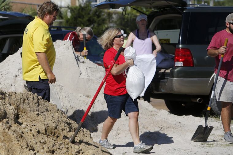 Residents of the Isle of Palms, S.C., fill sand bags at the Isle of Palms municipal lot where the city was giving away free sand in preparation for Hurricane Florence at the Isle of Palms S.C., Monday, Sept. 10, 2018. (AP Photo/Mic Smith)