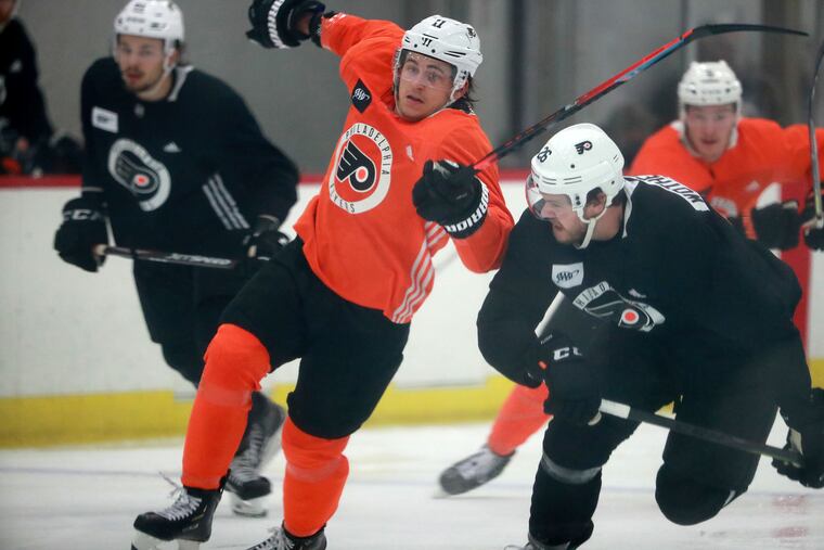 Travis Konecny (left) tries to skate around Tyler Wotherspoon at Flyers' training camp in Voorhees.