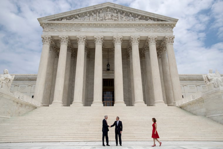 New Supreme Court Justice Neil Gorsuch (left,) shakes hands with Chief Justice John Roberts, as Gorsuch’s wife, Louise, arrives at right, at the Supreme Court on Thursday.
