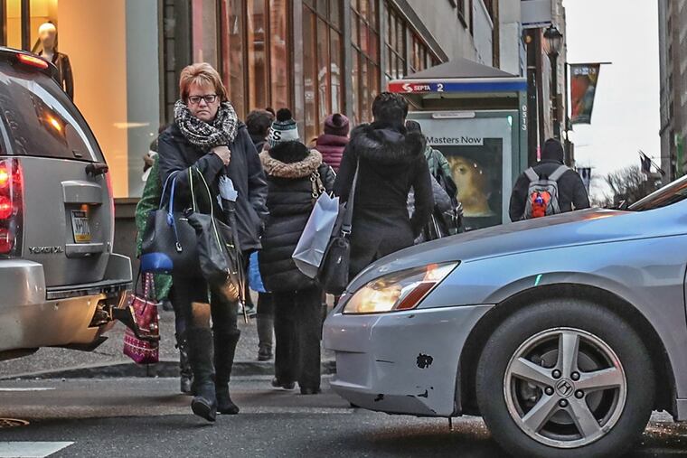 Pedestrians are forced to walk between cars that overshot their green light and block the intersection at 16th and Chestnut Streets.