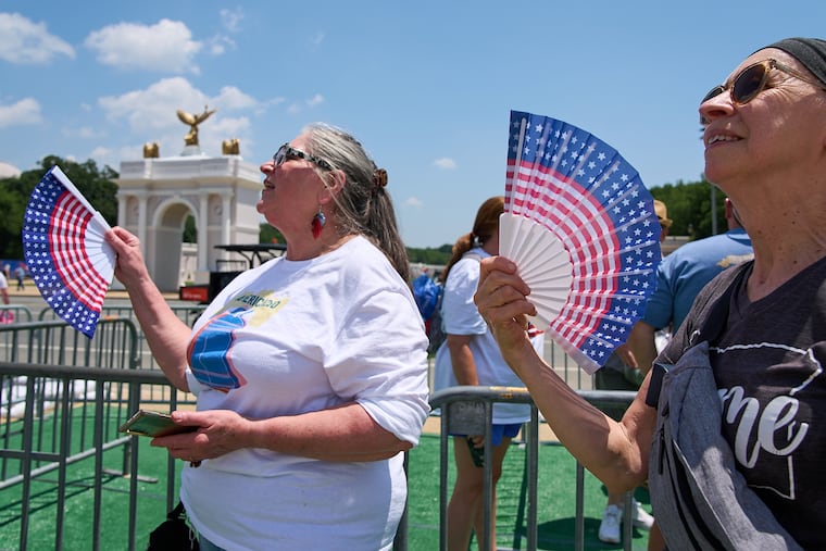 FILE - Mickelina Papotto, of Salem, Ore., left, and Lorie Odegaard, of Gaithersburg, Md., fan themselves while waiting in line for the ferris wheel at the Great American State Fair on the National Mall, July 1, 2026, in Washington. (AP Photo/Jacquelyn Martin)
