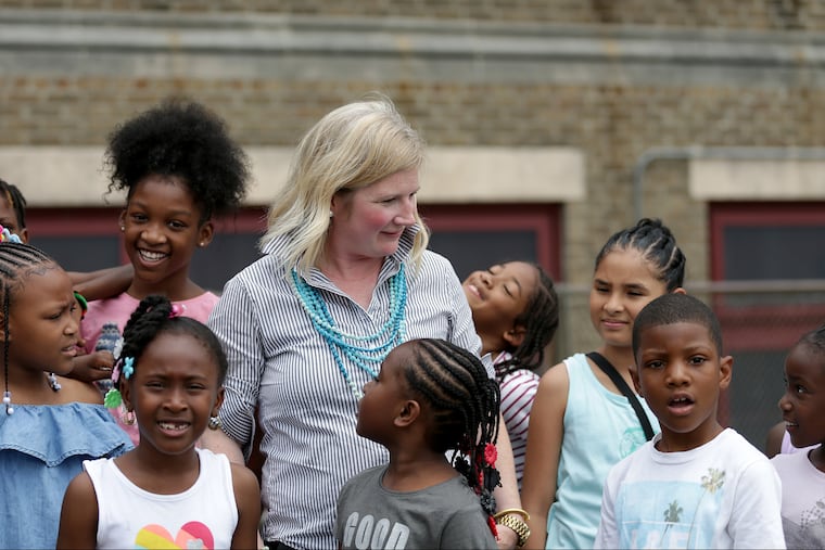 Jennifer Faustman, CEO of Belmont Charter Network, center, talks with students in a summer camp at Belmont Charter School this week. The charter currently leases the building from the School District, but wants to buy it, saying it's the only way to make needed repairs.