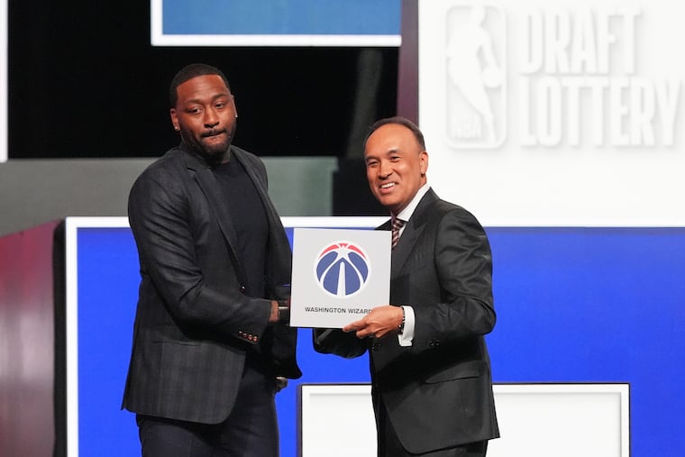 John Wall (left) and NBA Deputy Commissioner Mark Tatum pose for photos after Tatum announced that the Wizards had won the first pick in the NBA draft lottery on Sunday in Chicago.