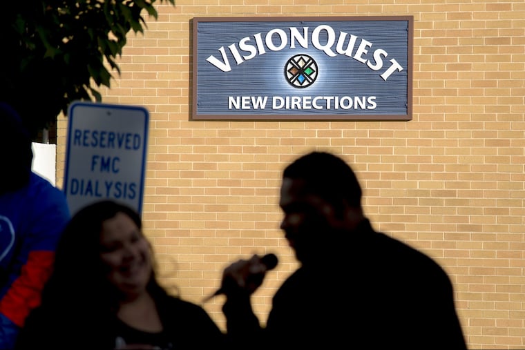 Protesters and Logan neighborhood residents opposed to plans by Arizona-based VisionQuest to house 60 undocumented immigrant children here gather outside the company's property on Wednesday. Speaking in front of the group are Erika Almiron, executive director of Juntos (left), and Josh Glenn (right) co-founder of the Youth Art and Self-Empowerment Project.