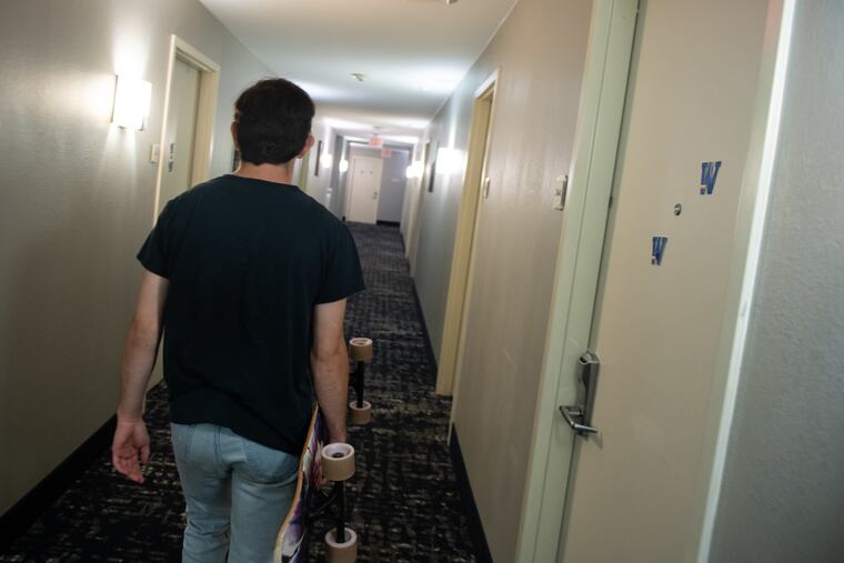 Sophomore James Henry, 19, walks down the hallway of the Best Western hotel where 80 Widener University students are living for the semester due to high enrollment.