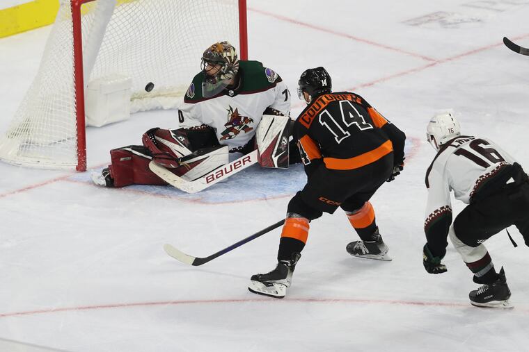 Sean Couturier, center, of the Flyers scores their first goal against Karel Vejmelka, left, of the Coyotes during the 3rd period at the Wells Fargo Center on Nov. 2, 2021. The Flyers won 3-0.