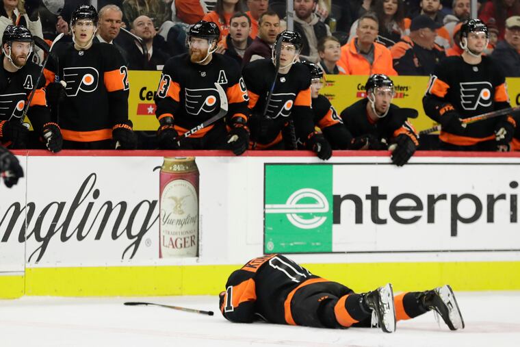 Travis Konecny lies on the ice after absorbing an open-ice hit Saturday against the Ottawa Senators.