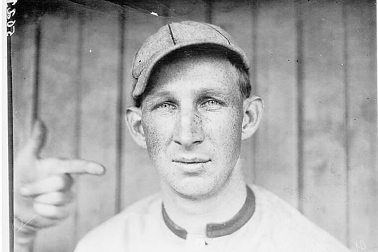 Photograph shows (Harvard) Eddie (Edward Leslie) Grant, third baseman for the Cincinnati Reds, head-and-shoulders portrait, facing front, with another person's left hand and index finger pointing at Eddie's head. Thompson may have been unaware that Grant began the 1911 season with the Cincinnati Reds and did not play a single game for the Philadelphia Phillies. (c1911 May 13) SOURCE: Library of Congress