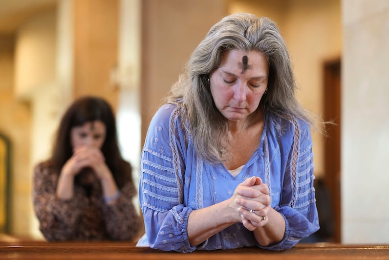 Dorsey Prince, right, and Shannon Carter pray during an Ash Wednesday Mass at St. John Neumann Catholic Church in Austin, Texas, in 2023.