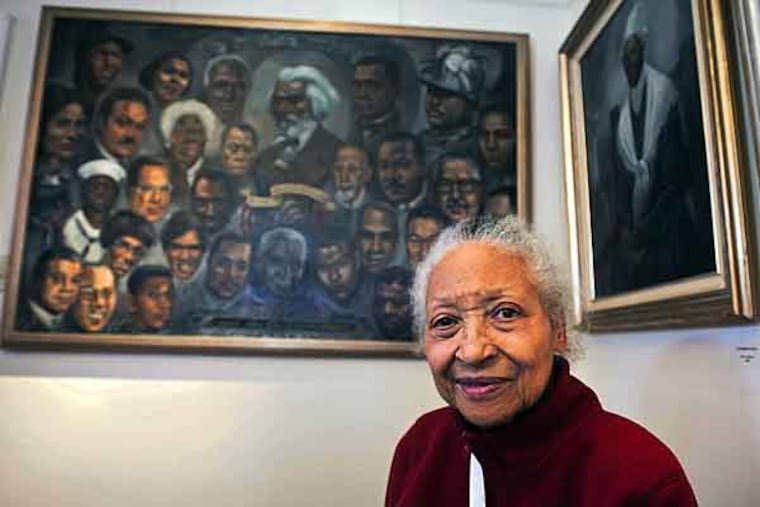 Willingboro resident Lady Bird Strickland, who was born into poverty in the foothills of Georgia and for more than six decades has painted aspects of African American life, sits with some of her paintings on display at Warden House in Mt. Holly. ( RON TARVER / Staff Photographer )