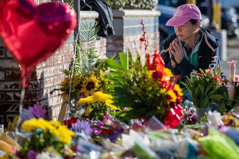 A woman who identified herself as Shally and said her dance partner died in Saturday's shooting at Star Ballroom Dance Studio in Monterey Park, pays her respects at a makeshift memorial outside the dance hall on Tuesday, Jan. 24, 2023 in Monterey Park, Calif.