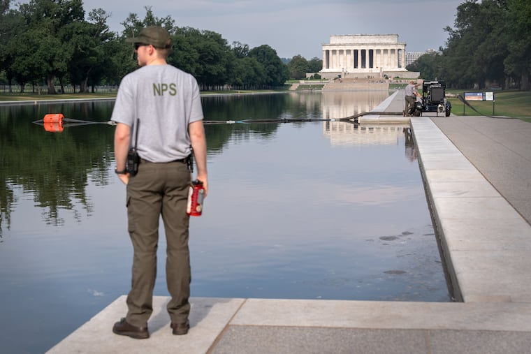 A National Park Service worker stands near a pump placed next to the Lincoln Memorial Reflecting Pool in Washington, July 10, 2026.