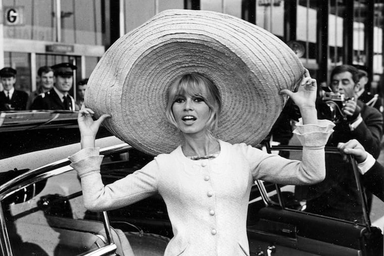 French actor Brigitte Bardot poses with a huge sombrero she brought back from Mexico as she arrives at Orly Airport in Paris, France, on May 27, 1965.