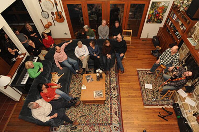 Bob Beach, on harmonica, and Phil Minissale, on guitar & vocals, perform a concert at the home of Lee Bowers for about 25 music lovers. (Bob Williams / For The Inquirer)