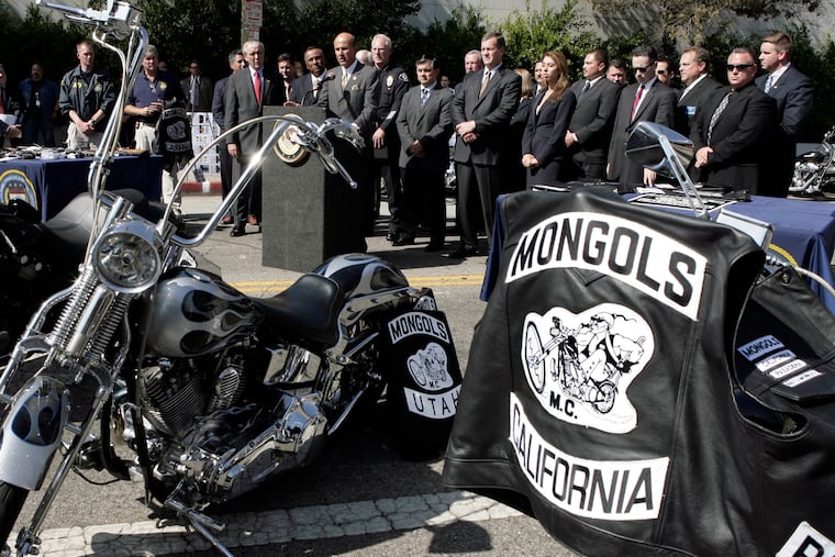 FILE - In this Oct. 21, 2008, file photo, Los Angeles County Sheriff Lee Baca, at podium, speaks during a news conference in Los Angeles with the trademarked Mongols logo seen on a motorcycle at right. A California federal judge has refused to order the Mongols motorcycle gang to forfeit its trademarked logo, delivering a blow to prosecutors. U.S. District Court Judge David O. Carter said Thursday, Feb. 28, 2019, that such an order would have been unconstitutional.