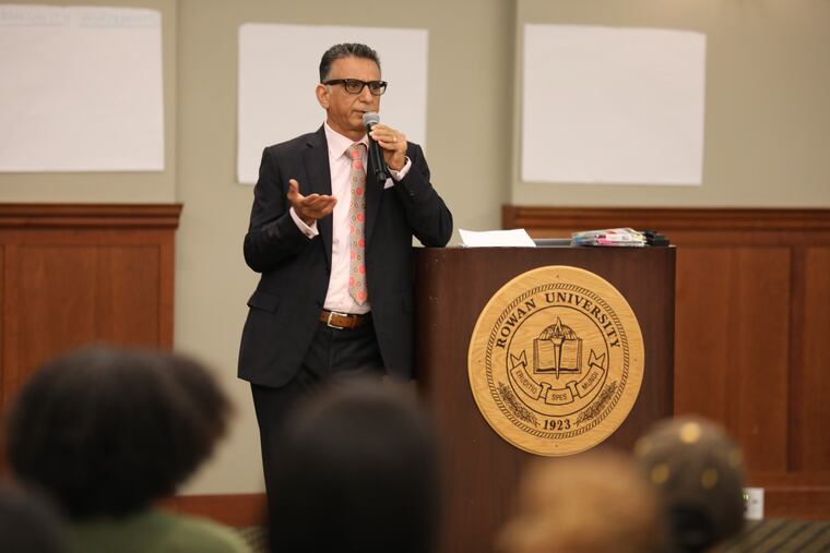 Rowan President Ali Houshmand speaks at a town hall meeting in October. On Friday, he reversed an earlier policy requiring student athletes wear shirts while practicing.
