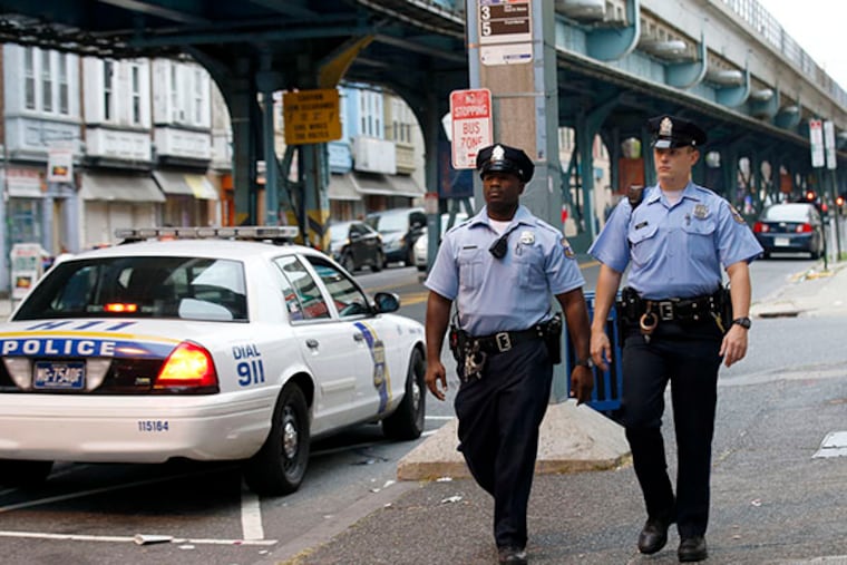 15th District Philadelphia Police Officers Josh Daniels (right) and Arne Vaughn pass a Highway Patrol car while the two patrol Frankford Avenue in Philadelphia on Monday, September 29, 2014. ( YONG KIM / Staff Photographer )