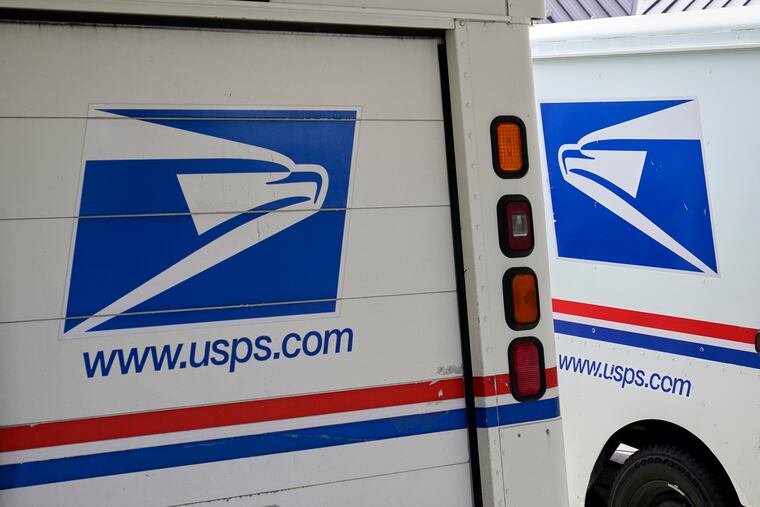 Mail delivery vehicles are parked outside a post office in Boys Town, Neb.