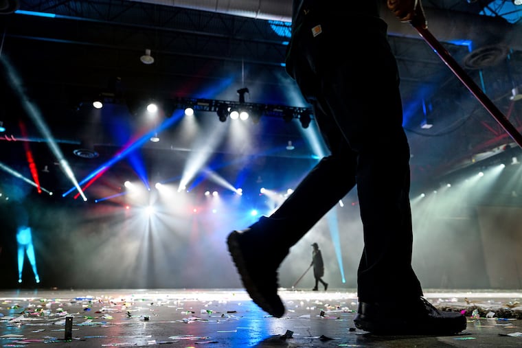 January 2, 2023: Crews sweep up the confetti left on the Convention Center floor between performances of the Fancy Brigade Finale, a part of Philadelphia’s Mummers 2023 parade.
