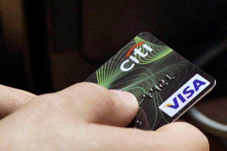 FILE - In this May 9, 2012 file photo, a Visa credit card is tendered at the opening of the Superdry store in New York's Times Square. More than 35 percent of Americans have debts and unpaid bills that have been reported to collection agencies, according to a study released Tuesday, July 29, 2014, by the Urban Institute. (AP Photo/Richard Drew, File)