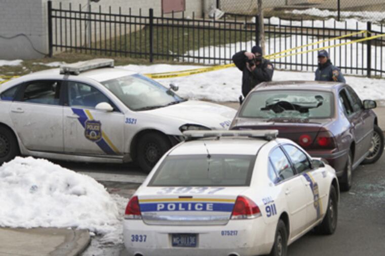 Investigators look over the suspect's vehicle at the intersection of 23rd Street and Susquehanna Avenue in North Philadelphia on Tuesday. (Joseph Kaczmarek / For the Daily News)