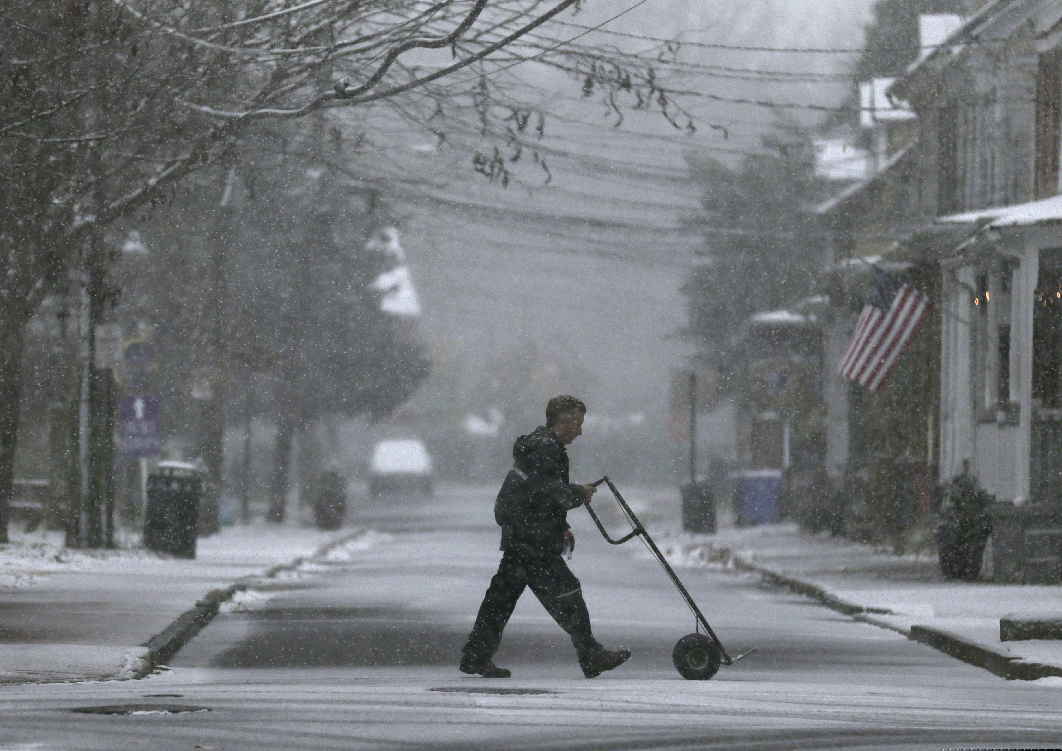 A delivery man makes his way through wintry weather in Mt. Holly, N.J., on a snowy day last year.