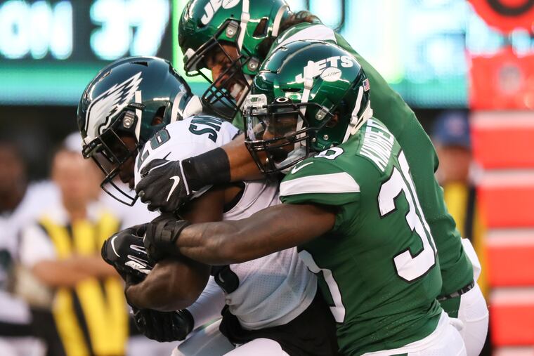 Eagles running back Wendell Smallwood gets stopped by a pair of Jets defenders Thursday night. Smallwood had just 23 yards on seven carries and had a fumble.