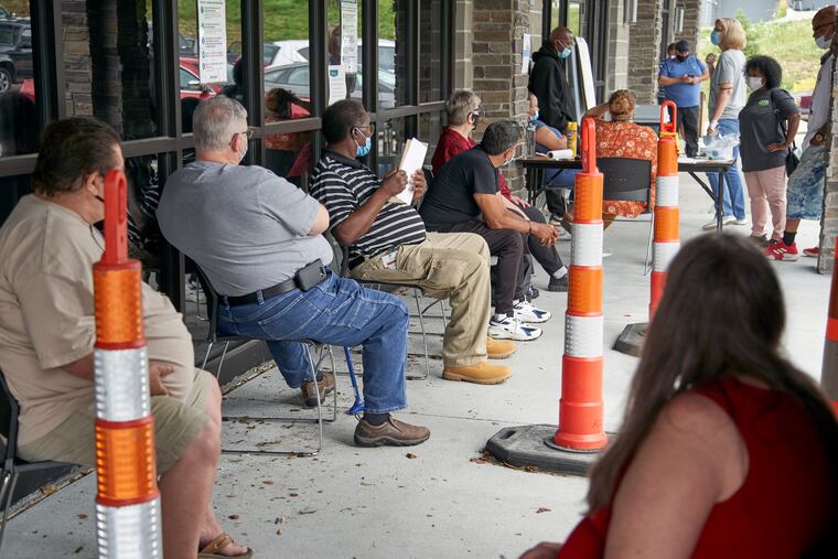 Job seekers exercise social distancing as they wait to be called into the Heartland Workforce Solutions office in Omaha, Neb.