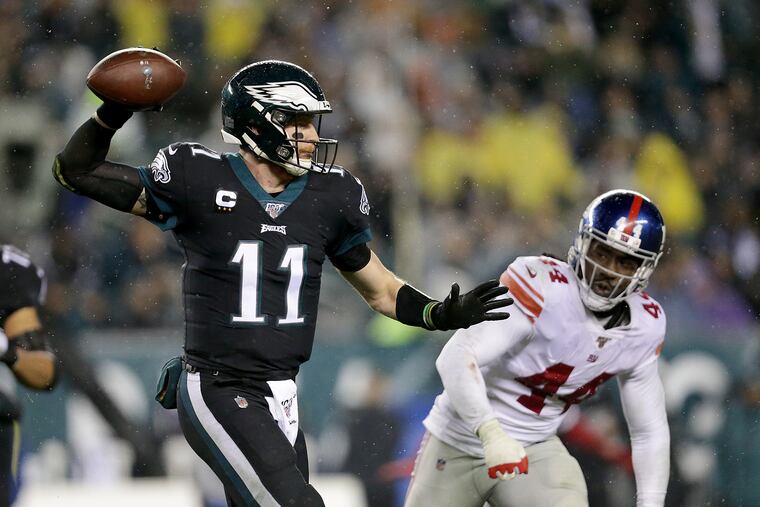 Eagles quarterback Carson Wentz scrambles as he throws a pass in the third quarter against the Giants.